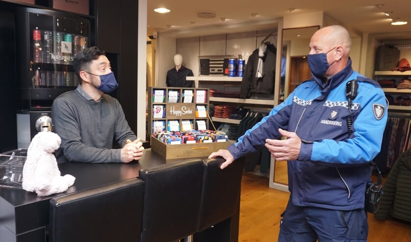 <p>BOA Jeroen Stam in gesprek met Carlos van Wees over de mondkapjesplicht. Wat moet je doen als er iemand binnen komt zonder kapje? Foto: VSK </p>