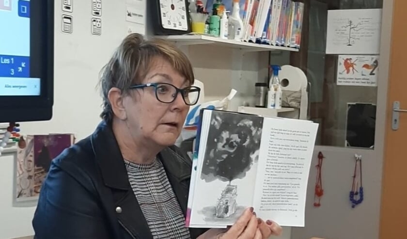 <p>Digitaal voorlezen aan de kinderen van groep 3. Het is even wennen voor Juf Conny van der Krogt. Foto: PR</p>
