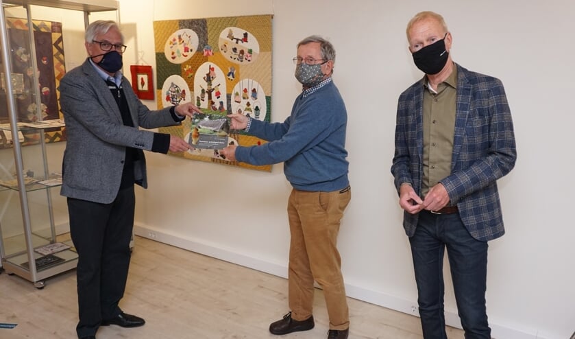 <p>Wethouder Cramwinckel ontvangt van Pierre van Grinsven het boekje 'Voorschoten archeologisch bezien' onder het toeziend oog van bestuurssecretaris van Museum Voorschoten Jan Koster </p>