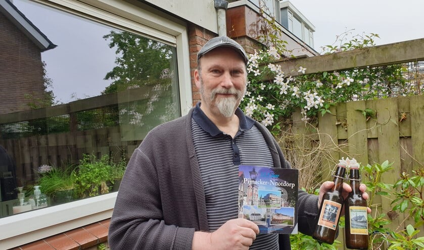 Erik met bier en boeken in de groene achtertuin van zijn vriendin.