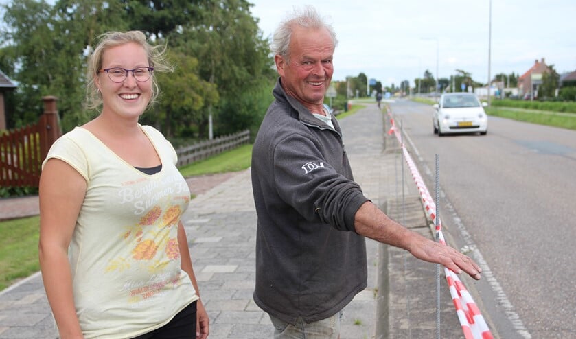 Jolanda en Ton de Vreede zijn tegen het plan om tussen het fietspad en de weg een haag te maken. Ze hebben een lint gespannen om aan te geven hoe hoog die haag zou kunnen worden.