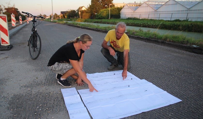 Op de tekening van Delfland gaat de afwatering naar twee kanten en loopt de weg rond. Op de tekening van de gemeente gaat de totale afwatering naar de vaart en daarom wordt de weg 25 centimeter hoger.