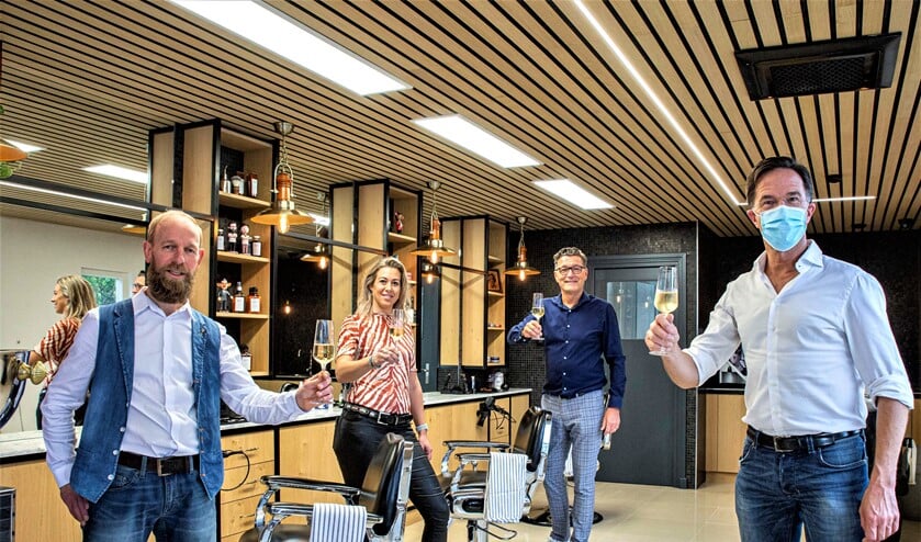 <p>Marco Rimmelzwaan (l.) en de andere teamleden proosten met Mark Rutte op de heropening van de zaak (foto: Harry Scholtes).</p>