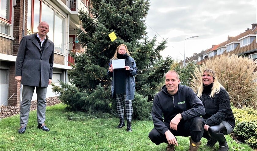 <p>Burgemeester Klaas Tigealaar kwam hoogstpersoonlijk langs op de Von Geusaustraat om de vergunning te overhandigen en zelf ook een kerstwens in de boom te hangen (foto: gemeente LV).</p>