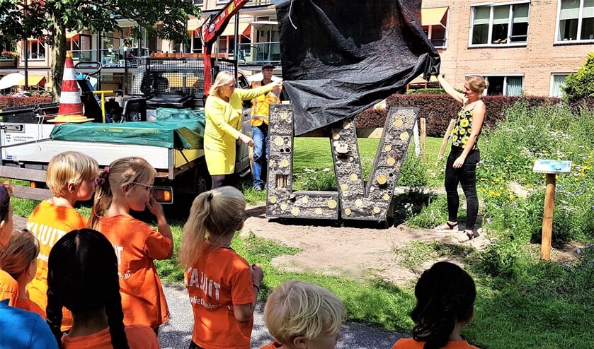 De wethouder opent het bijenhotel achter het voormalige raadhuis van Leidschendam (foto: pr gemeente LV).
