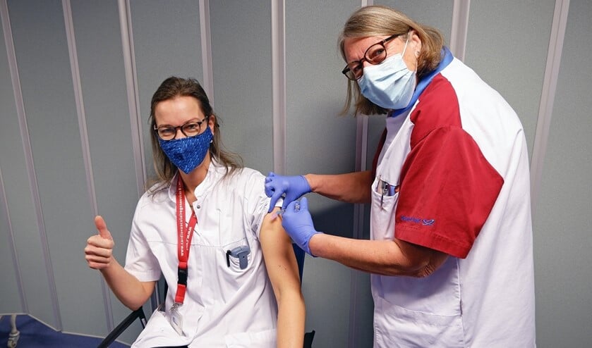 <p>Internist Nicole van der Linde krijgt een vaccinatie toegediend van haar collega SEH-verpleegkundige Marjo Hanegraaff. </p>