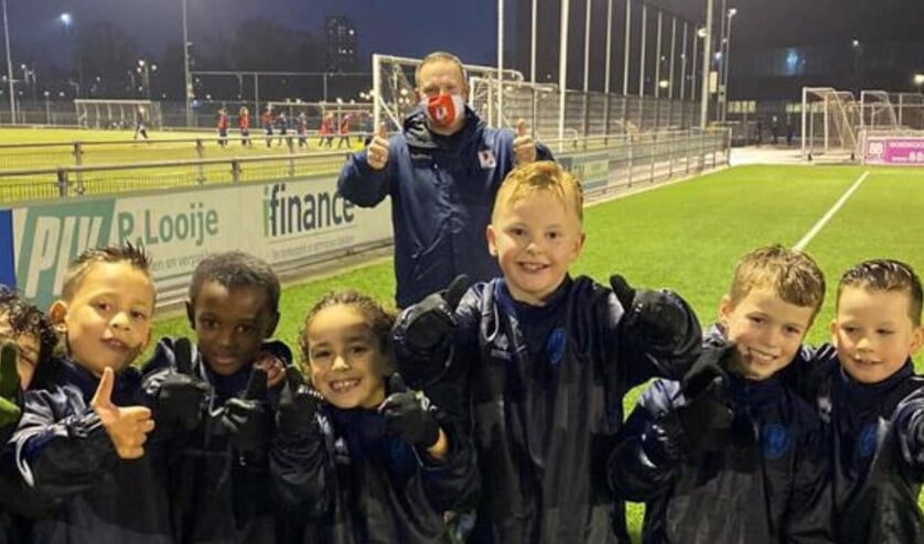 <p>Kevin Koppe met de spelers van ADO O9.</p>