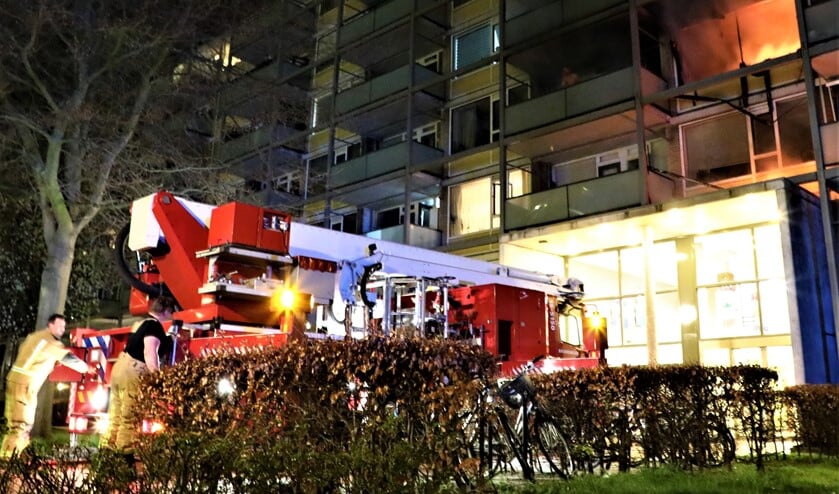 <p>Toen de brandweer aankwam sloegen de vlammen uit het pand en moest de bewoner van het balkon worden gehaald met een hoogwerker (foto: Sebastiaan Barel).</p>