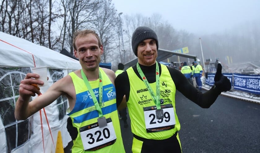 Erwin Harmes (320) met nummer twee Wouter Decock zijn blij na hun finish van de marathon van Spijkenisse. Harmes won in een recordtijd.