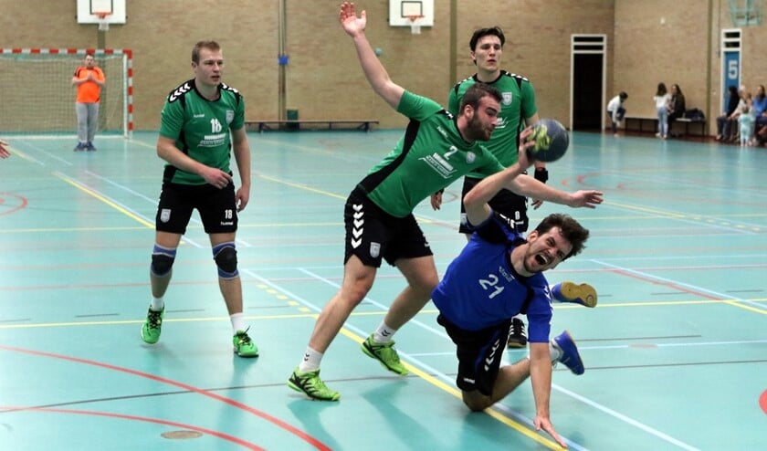 Jos van der Velden probeert van zijn belagers te slim af te zijn en te scoren tegen Helius.