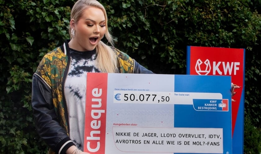 <p>Nikki de Jager met de cheque voor KWF. Foto: (AVROTROS)</p>