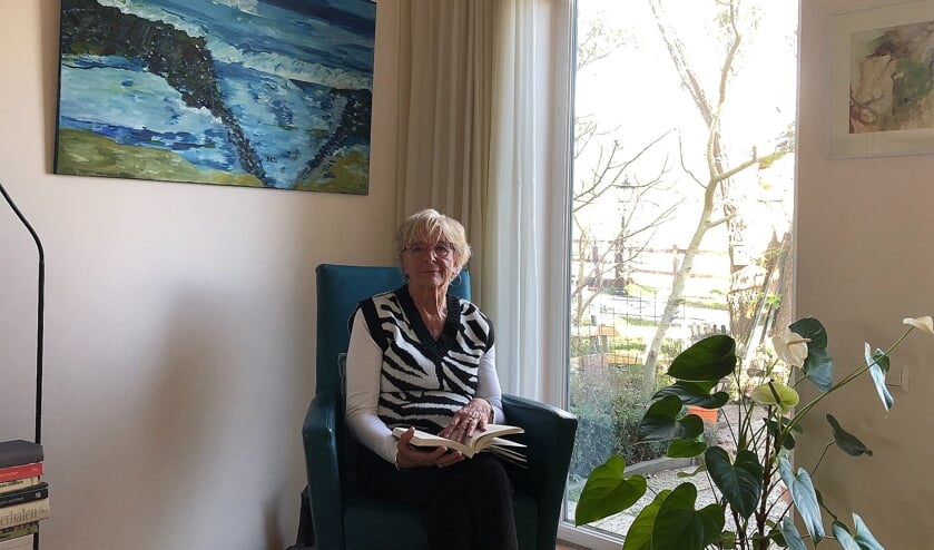 <p>Roos van Houwelingen-Kok voor een van haar zelf gemaakte schilderijen</p>