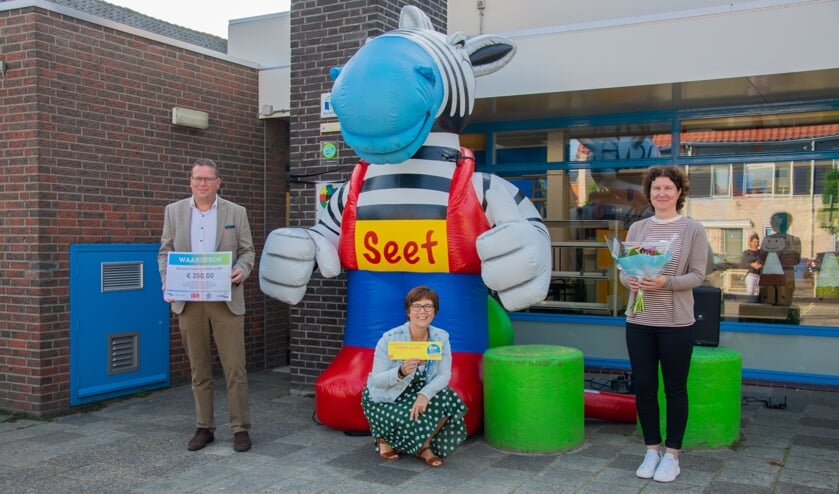 Een nieuw bordje voor naast de deur, een cheque van 250 euro en natuurlijk een bloemetje voor de verkeersmoeder. Obs Roxenisse is weer hartstikke veilig! Foto: Sam Fish
