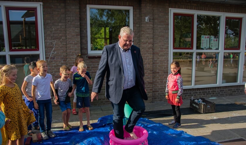 Wethouder Peter Feller moet toch wel even schrikken van de koude ijsblokjes in het bad. De kinderen vinden het hilarisch! Foto: Sam Fish