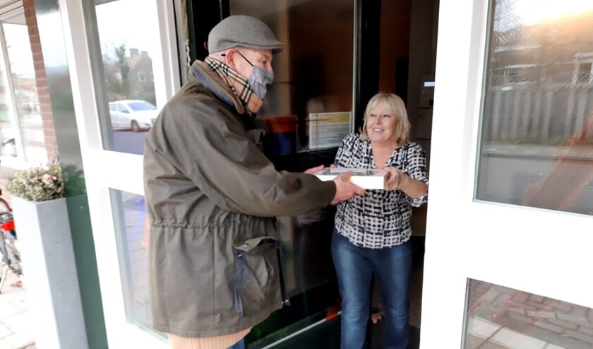 <p>Boy Wildeboer geeft de taart voor de vrijwilligers af.</p>