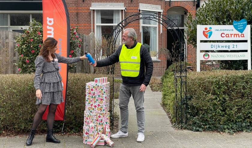 <p>Mariska Bakker, coördinator van Carma, neemt de eerste blauwe thermosfles in ontvangst. Foto: (PR)</p>