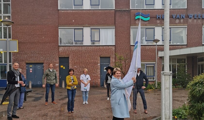 <p>Foto: Afdelingshoofd Désirée Luijten hijst symbolisch de vlag © CuraMare</p>