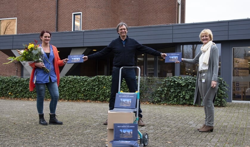 <p>Joëlle Piguillet en Lydi Brouwer van De Bieslandhof ontvangen de boeken van Herman Zonderland (Foto: Aad Derwort) </p>