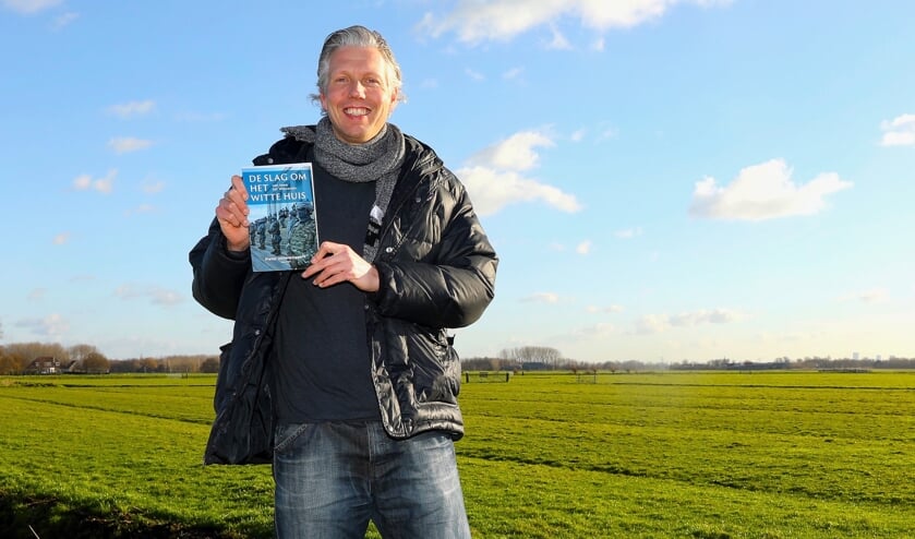 <p>Pieter Uittenbogaard met zijn recent verschenen boek op een van de mooiste plekjes van Delft. Foto: Koos Bommelé</p>