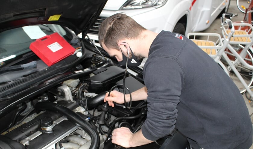 <p>Een monteur luistert met een stethoscoop naar de motor. (Foto: EvE) </p>