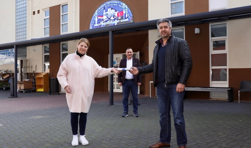 <p>De burgemeester reikt de Gouden Klinker uit aan Orhan Yasar <br>(Foto: Koos Bommelé)</p>
