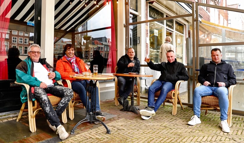 <p>Bezoekers genieten van een biertje op een terras op de markt. (Foto: Koos Bommelé)</p>