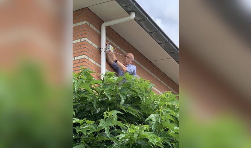 <p>De fijnstofmeter wordt geïnstalleerd aan de gevel van een huis.</p>