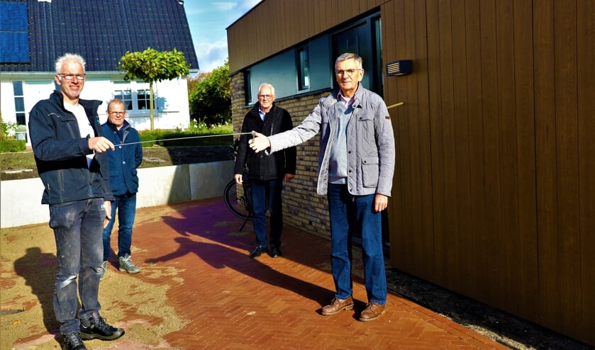 <p>Via een ijzeren staafje krijgt Rinus Bosman de sleutel van het pand van uitvoerder Jan-Willem Palsgraaf. </p>