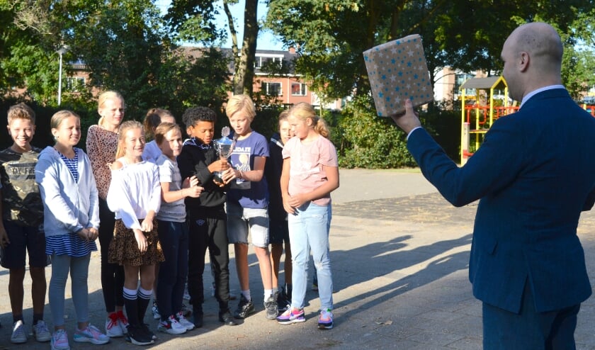 Een beker en een cadeau van wethouder Jan Willem Schuurman voor groep 8 van de Nieuwerkerkse Montessorischool. (foto en tekst: Judith Rikken)
