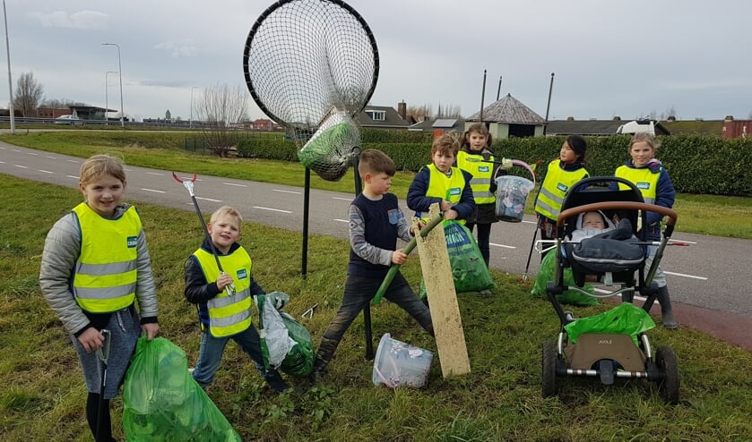 <p>Kinderen uit de buurt van de Henegouwerweg worden door Willem van Dorp aan 'het werk' gezet met prikkers en afvalzakken.</p>