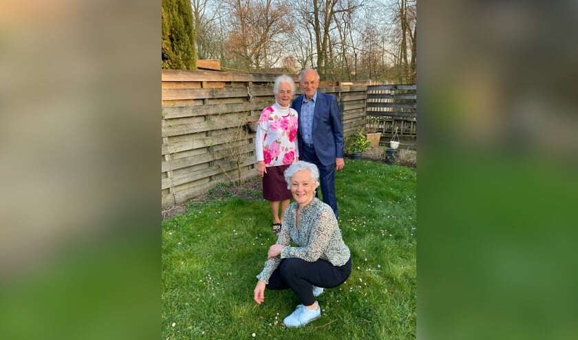 <p>Boukeline Bac, zittend in het gras, met haar ouders voor wie zij mantelzorger is.</p>