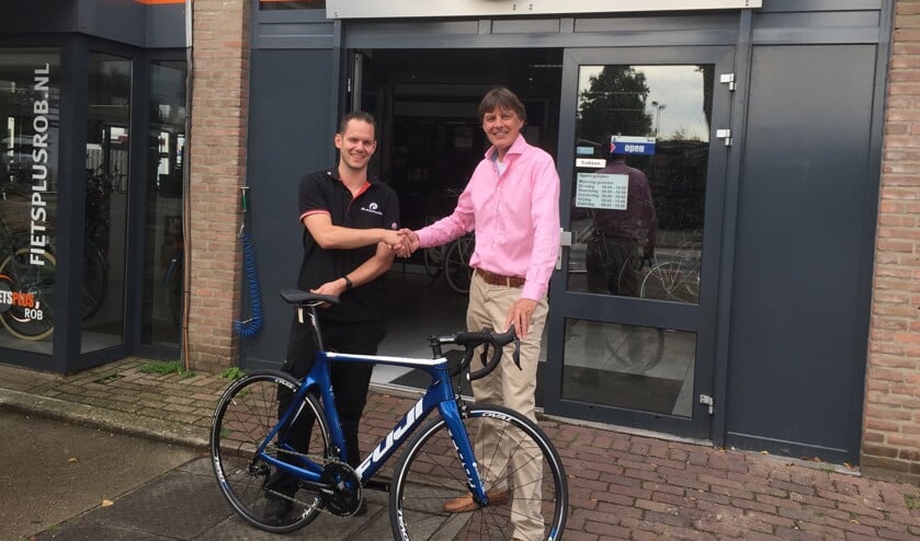 Wim Melsen (rechts) neemt de fiets in ontvangst van Rob van Hulten, eigenaar van Fietsplus Rob.