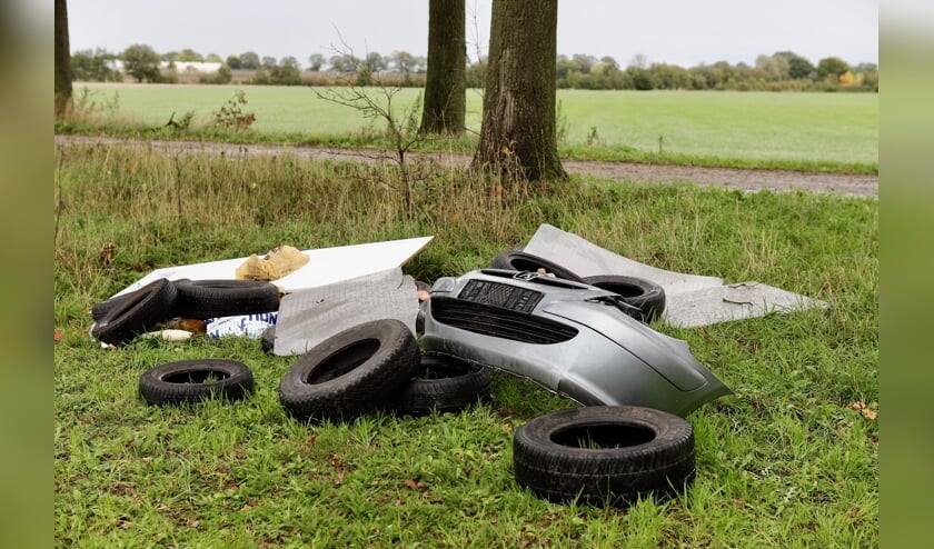 Auto-onderdelen en banden gedumpt in een weiland in Beers.