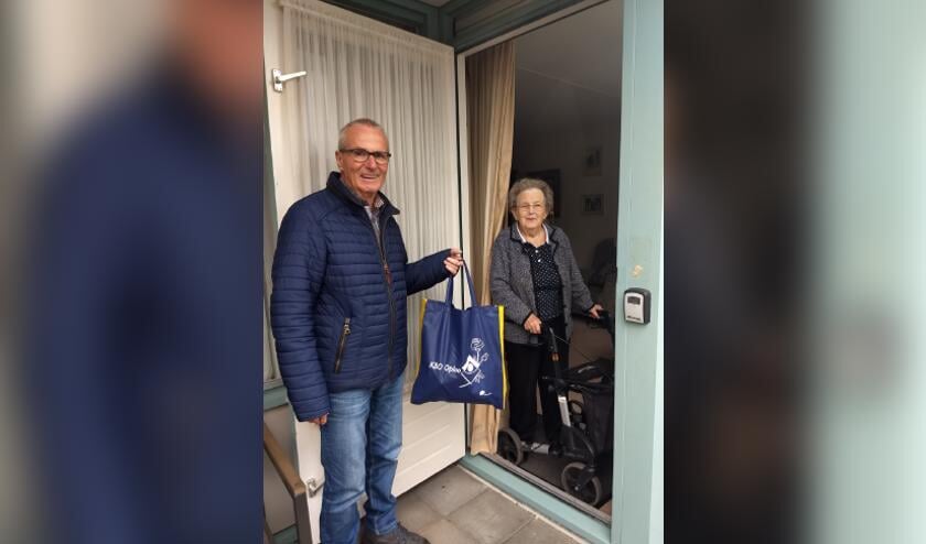 Foto KBO Oploo. voorzitter Jan Peeters overhandigd tas aan mevr. Marietje Fransen-Verlienden.