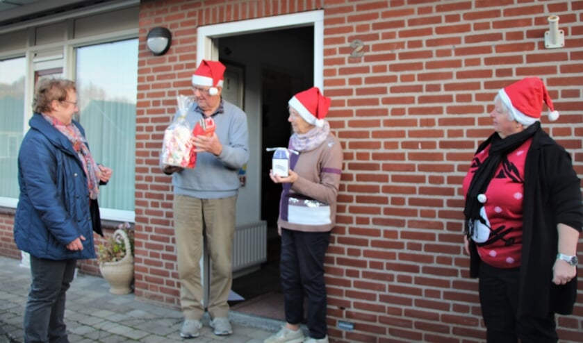 <p>Links dirigente Els Thijssen en rechts Nelly van de Heuvel. Ze verrassen de koorleden Peter en Maria Claassen.</p>