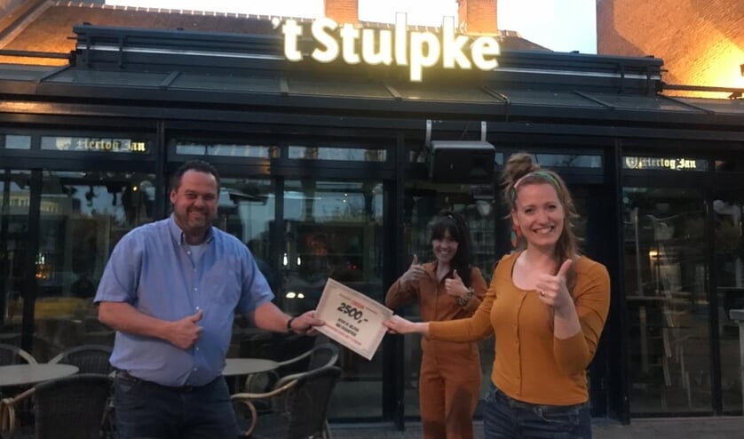 Dick van Zutven overhandigt de cheque aan de dames van 'Helden van Bernhoven'.