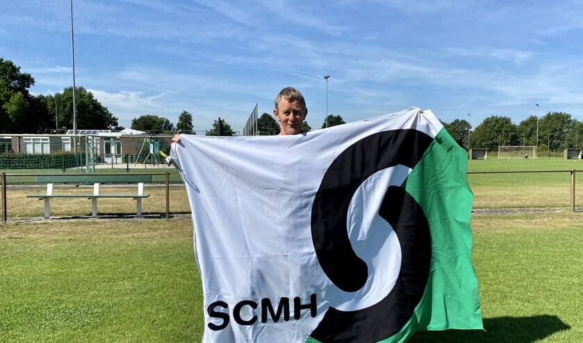 Bert van de Broek met de vlag met daarop het nieuwe logo.