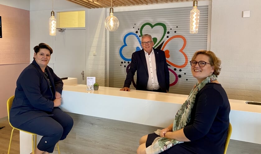 <p>Bestuursleden Yvon en Nathaly zitten aan de vernieuwde bar. Voorzitter Hans staat er tussenin.</p>