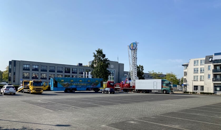 De opbouw van de kermis is inmiddels begonnen, links wordt een auto weggesleept.
