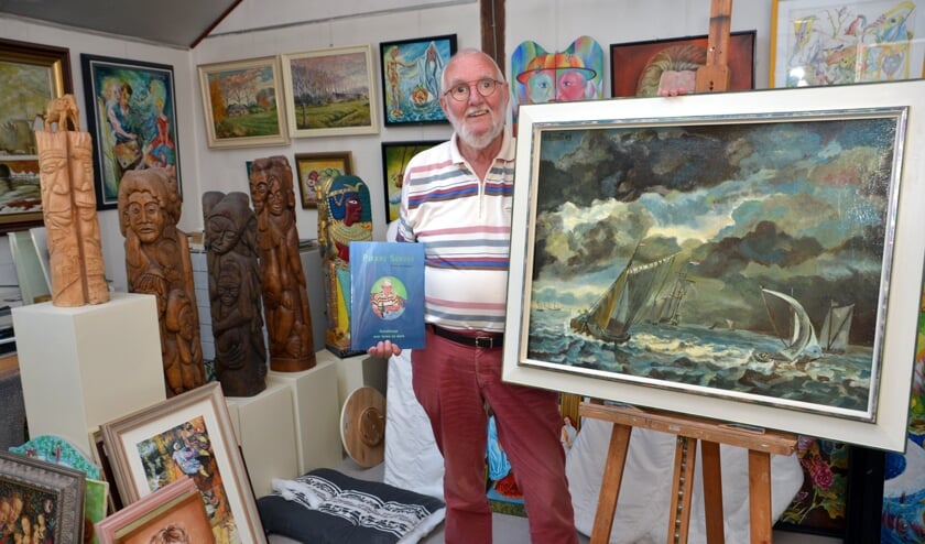 Pierre tussen zijn kunstwerken, met zijn boek in zijn hand. (foto: Henk Lunenburg)