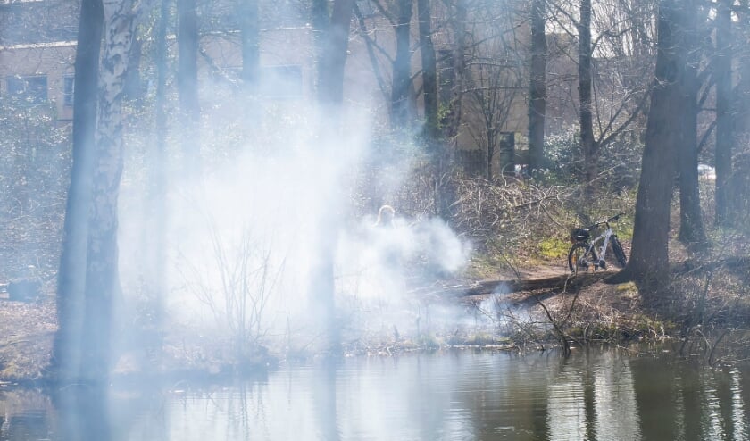 Politieman en handhaver blussen buitenbrand in Joost van den Vondellaan. (Foto: Gabor Heeres, Foto Mallo)