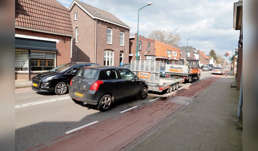 Een zwarte Suzuki botste achter op een wagen met aanhanger.