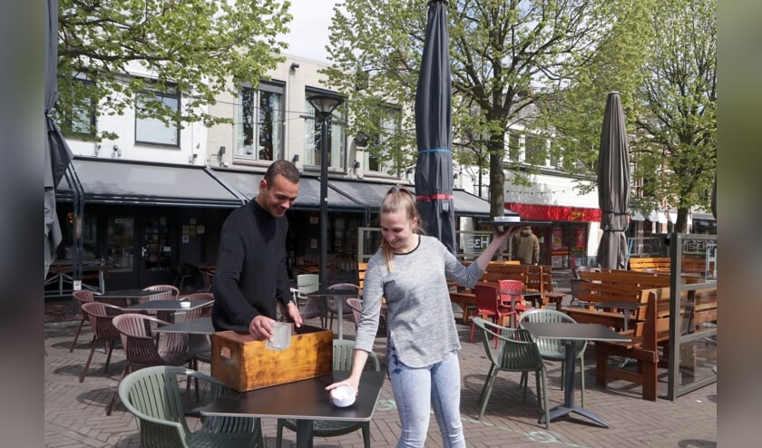 <p>Medewerkers van restaurant H32 maken het terras gereed.</p>