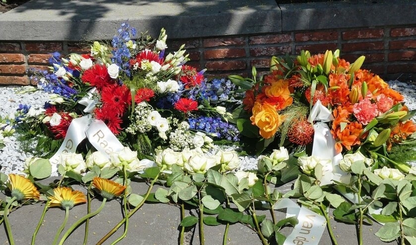 Burgemeester Teunissen legt op 4 mei een krant bij het monument op het Vrijheidsplein in Gennep.