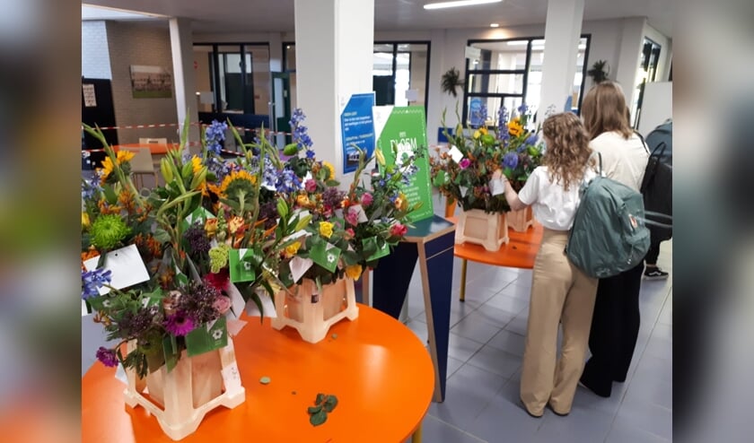 <p>Leerlingen van Het Hooghuis maken een keuze uit het aanbod aan bloemen.</p>