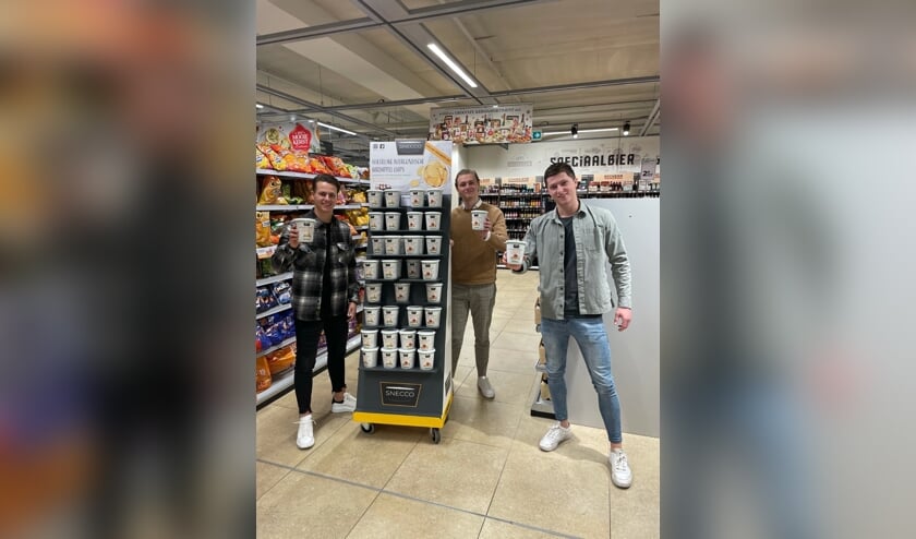 <p>De drie studenten bij een display met de door hun bedachte Snecco-chips.</p>