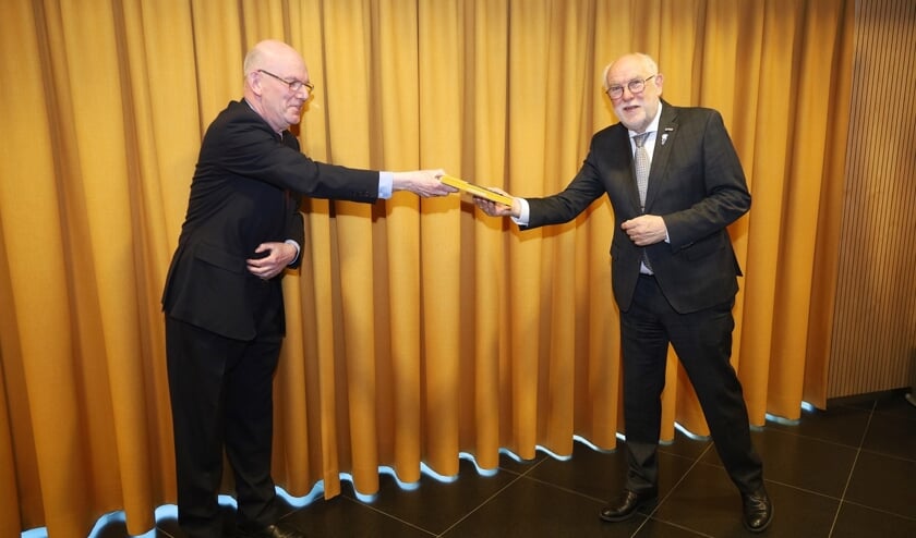 v.l.n.r.: Voorzitter van BING Wim Goossens reikt het eerste boek uit aan burgemeester Karel van Soest.