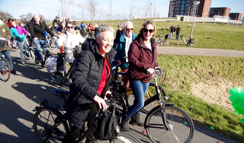 Wethouder Van Tatenhove en initiatiefnemer Silvia Wessels nemen samen met leerlingen van De Poolster al zingend het Zangfietspad in gebruik.