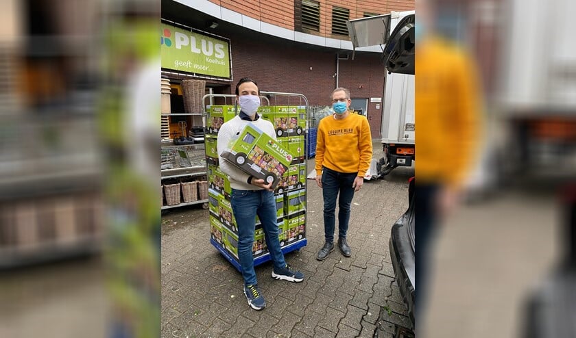 <p>Jordy Koelhuis (links) en Wim de Heer in de weer met de 125 pakketten.</p>