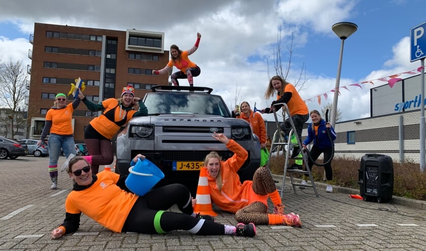 <p>Leden van Volley2B nemen een grote Landrover onder handen.</p>